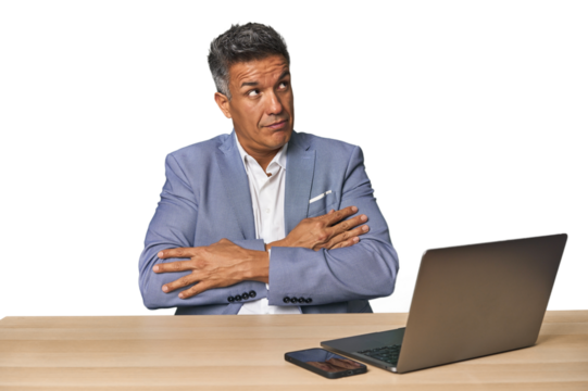 Elegant businessman at desk with laptop dreaming of achieving goals and purposes