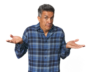 Middle-aged Latino man doubting and shrugging shoulders in questioning gesture.