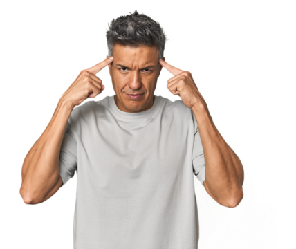 Middle-aged Latino man focused on a task, keeping forefingers pointing head.