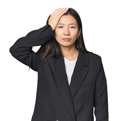 Young Chinese woman in business suit being shocked, she has remembered important meeting.