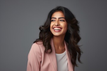 Portrait of a smiling young woman of Indian ethnicity having long flowing hair - obrazy, fototapety, plakaty