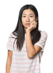Fototapeta premium Young Chinese woman in studio setting biting fingernails, nervous and very anxious.
