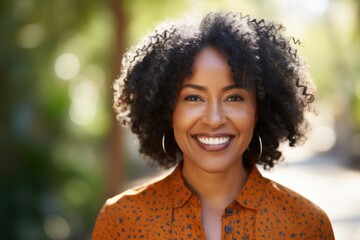 Cheerful african american mid adult woman smiling outdoor. Beautiful black lady laughing at park.