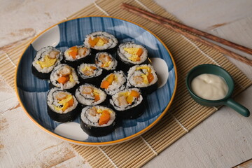 Gimbap, also romanized as kimbap, is a Korean dish made from cooked rice and ingredients such as vegetables, fish, and meats. Sushi roll.