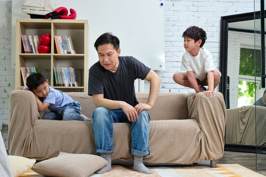 Father and children playing on the sofa