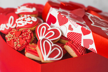 Homemade ginger cookies in the shape of a heart in red icing sugar. Delicious ginger cookies heart on a light concrete background. Freshly baked gingerbread cookies for Valentine's Day.