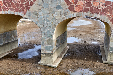 stone bridge over a dried-up swampy river