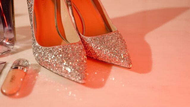 Glamorous glitter high heels on a pink surface.
Fashionable women's footwear with a shiny finish.
Ideal for stock sites related to fashion, luxury, and shopping.