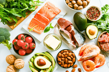 Flat lay shot of natural products compatible with the keto or ketogenic diet. Vegetables, avocado and animal protein.