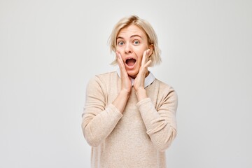 Portrait blond young woman smiling joyfully touching happy shocked face isolated on white studio background, advertising banner.