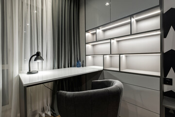 table lamp on work room with shelves in minimalist style in dark colors