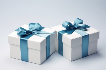 Two white boxes adorned with blue ribbons and bows. Perfect for gift-giving or special occasions