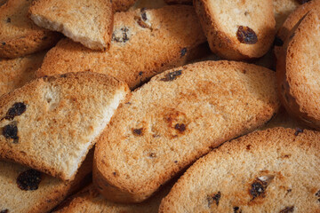 The sweet rusks with raisins. Homemade crunchy pastry, dried bread for tea drinking. Closeup view. - 722958987