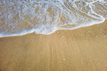 Des bulles de l'ecume des vagues sur un sable blond d'une plage paradisiaque de vacances