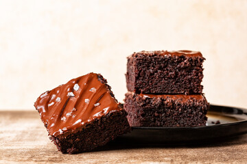 Stack of Cutted square peaces of dark chocolate moist buttermilk sheet cake with chocolate butter...