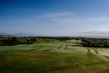 Sotogrande, Spain - January, 23, 2024 - Elevated view of a golf course with mowed fairways leading...