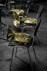 a brass musical instrument horn lying on a chair
