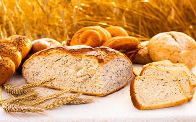 Lot of different flavored bread, wheat, rye, on the table in the field outside