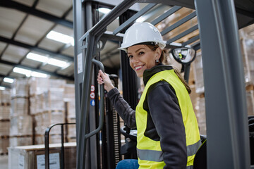 Female warehouse worker driving forklift. Warehouse worker preparing products for shipmennt,...