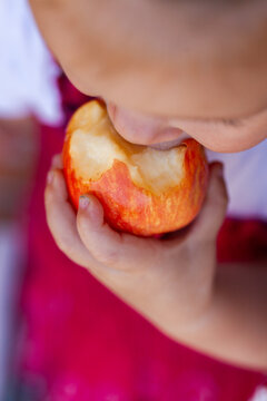 Toddler biting into small apple fruit snack