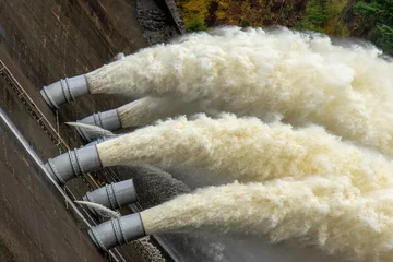 Fotobehang Laggan dam with powerful water flowing through pipes © Sarah