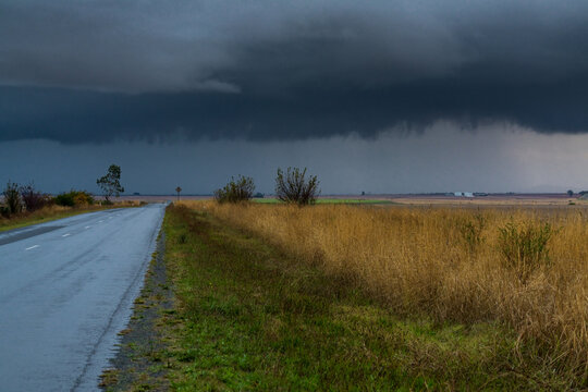 Rain falling from a dramatic stormfront over rural farmland