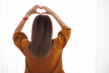 woman raised her hands and made heart symbol to express meaning of love friendship and kindness to her friends and lovers. woman uses her hands to make a heart symbol that means love and friendship.