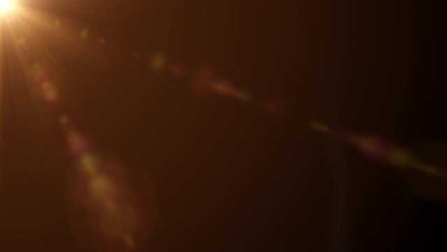 Loop of rays glow orange gold optical flare shine light from the top left animation on black abstract background. Side diagonal light optical lens flares shiny animation art 