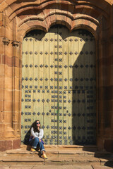 Mujer sentada frente a un portal mirando al horizonte