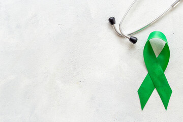 Green ribbon symbol of why cancer and mental health awareness concept
