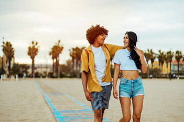 Romantic couple holding hands in their vacation standing on a beach by the sea. A loving couple is...