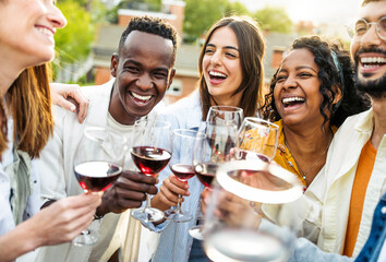 Happy friends toasting red wine glasses outside - Group of young people having bbq dinner party in backyard house - Winery and bbq dining concept with guys and girls cheering alcohol together