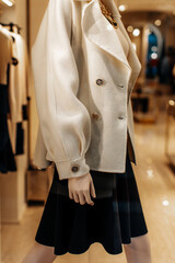 Fancy details of a classic white jacket with golden buttons and black skirt. Women's fashion clothing and accessories