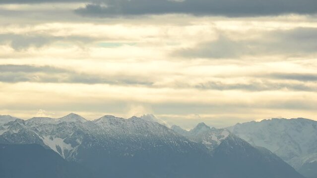 Snowy Alps behind Starnberg lake in a yellow cloudyb autumn evening near Munich