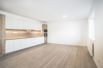 A Modern kitchen with white cabinets, a wooden countertop, built-in appliances, and a spacious layout.