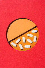 White tablet pills on orange and red background