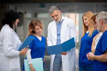 Team of doctors discussing unique medical case, walking across corridor. Colleagues, doctors team...