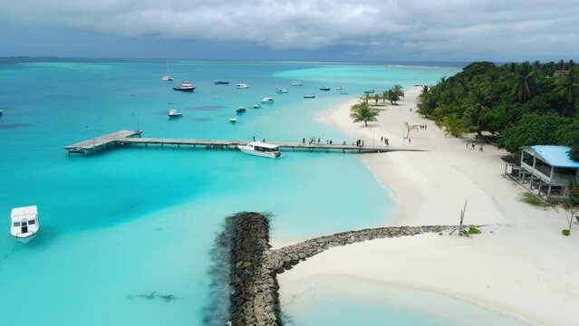 Aerial view of Maldives tropical beach with pier and speed boats in ocean. Summer and travel vacation concept.