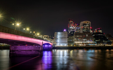 Fototapeta na wymiar London. UK-01.27.2024. London Bridge at night with the skyscraper in the City of London in the background and light reflections on the Thames river.