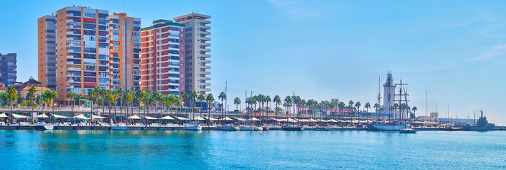 Malaga Port panorama with high rises and lighthouse, Spain