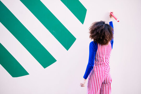 Woman with pencil writing on wall