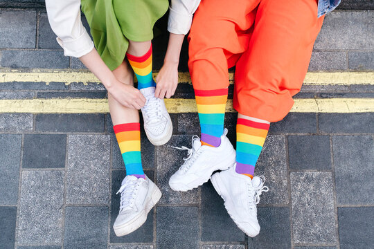 Young lesbian couple wearing multi colored socks at footpath