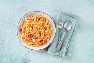 Carbonara pasta dish, traditional Italian spaghetti with pancetta and cheese, overhead flat lay shot with a fork and a spoon