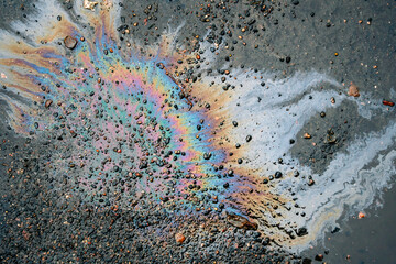 dirty multi-colored stain from engine oil on asphalt