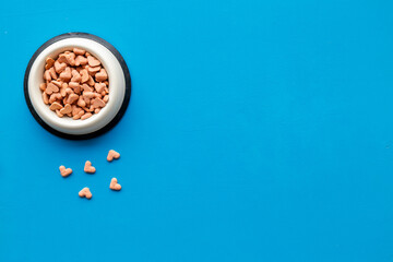 Bowl of biscuits for pets - food in a shape of heart, top view