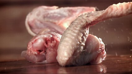 Chicken wings fall on a cutting board. Filmed on a high-speed camera at 1000 fps. High quality FullHD footage