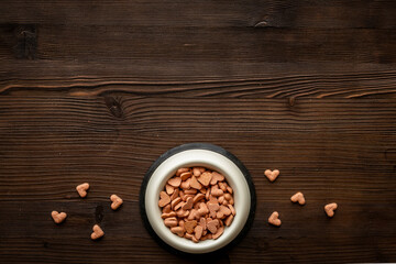 Bowl of biscuits for pets - food in a shape of heart, top view