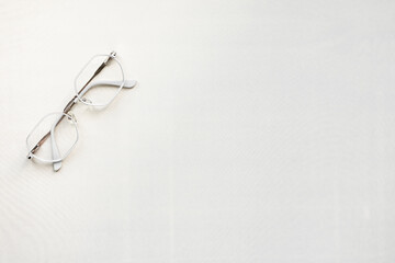 metal-framed glasses on a light background. free space for text. photo from above