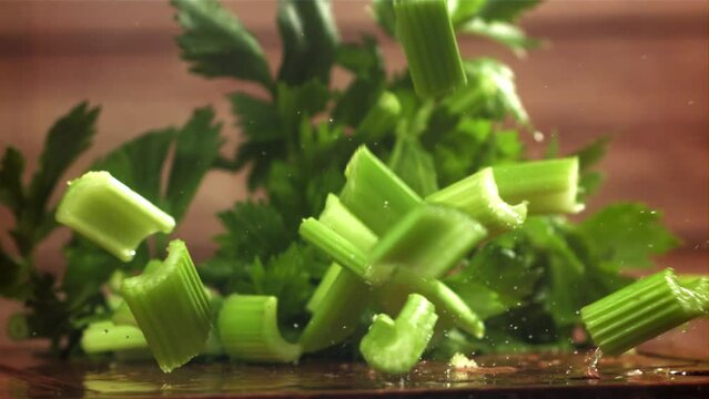 Pieces of chopped celery fall on the table. Filmed on a high-speed camera at 1000 fps. High quality FullHD footage