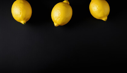 image shows three lemons arranged in a row on a black background